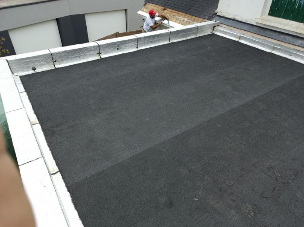 Artisan couvreur rénovant un toit plat à Nœux-les-Mines